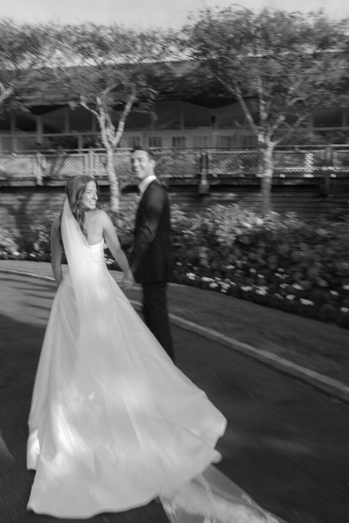Bride and groom walk hand in hand at their Bridgehampton Tennis & Surf Club wedding.