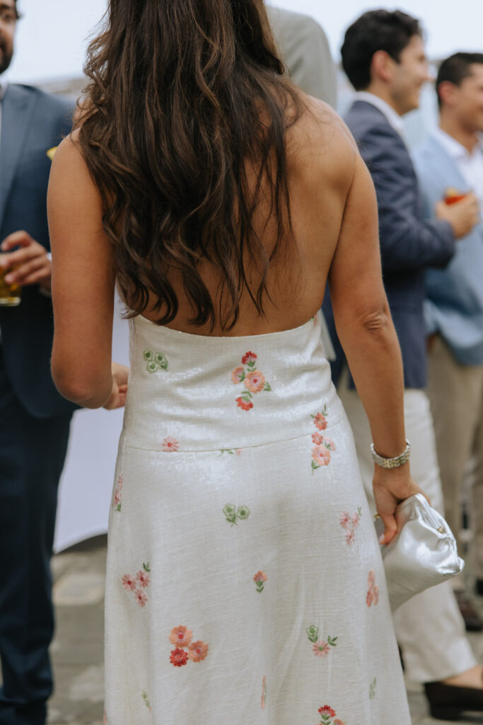 Woman in a white floral dress with an open back at a Bridgehampton Tennis & Surf Club wedding.