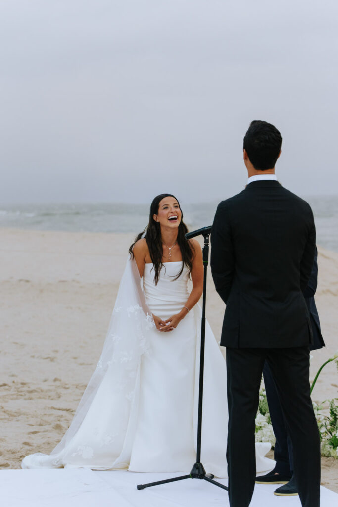 A bride laughs during her beachfront wedding ceremony at Bridgehampton Tennis & Surf Club.