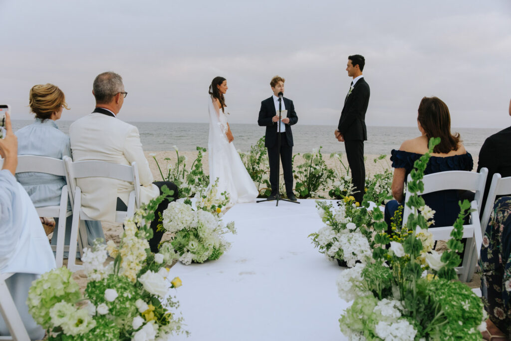 A couple exchanges vows during their beach wedding ceremony at Bridgehampton Tennis & Surf Club.
