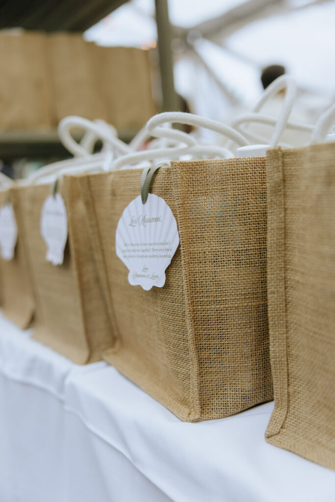 Jute wedding welcome bags with shell-shaped tags at a Bridgehampton Tennis & Surf Club wedding.