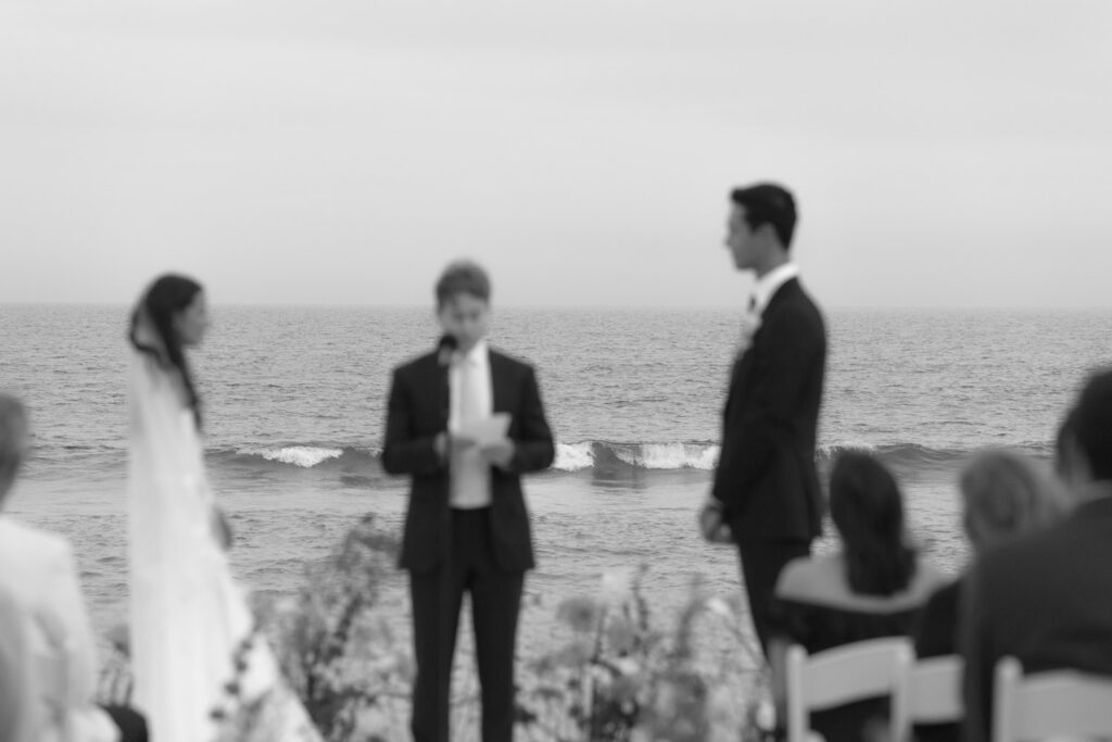 Wedding guests sit during an oceanside ceremony at Bridgehampton Tennis & Surf Club.