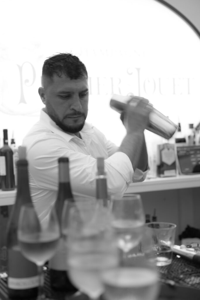 A bartender shakes a cocktail at a Bridgehampton Tennis & Surf Club wedding in Bridgehampton, NY.