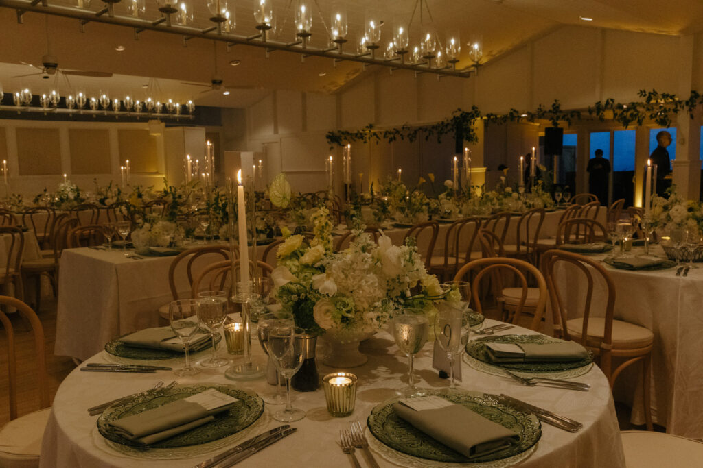Candlelit reception tables with white and green florals at a Bridgehampton Tennis & Surf Club wedding.