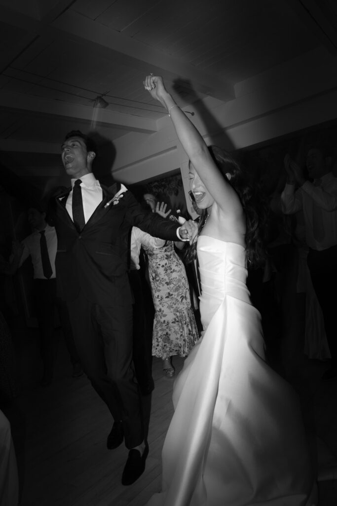 A newlywed couple dancing and singing during their Bridgehampton Tennis & Surf Club wedding reception.