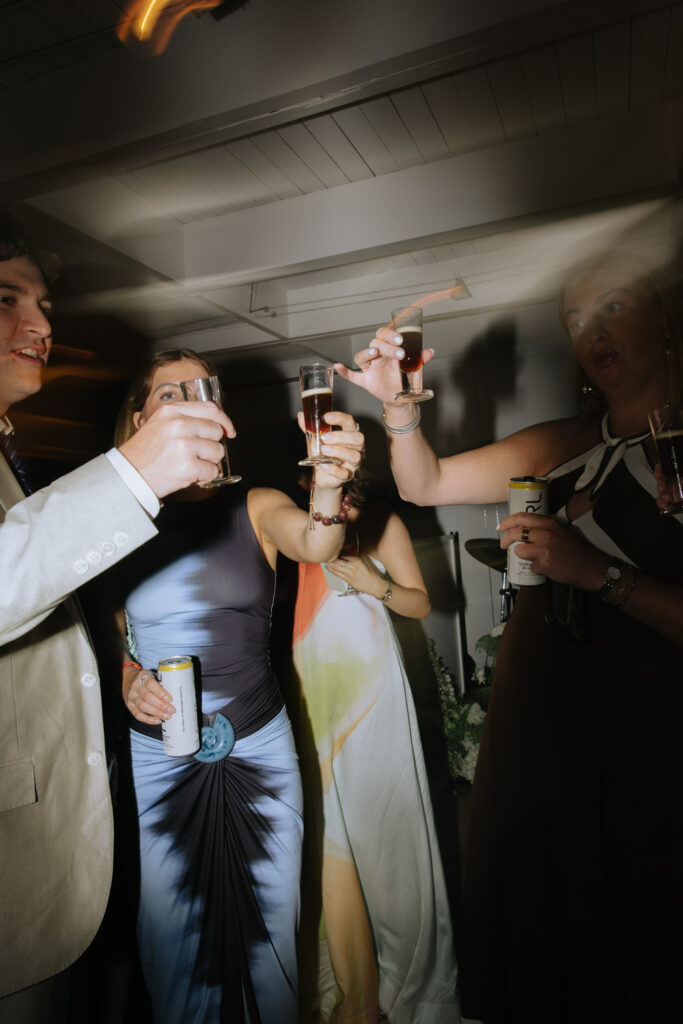 Guests clink glasses and toast at a Bridgehampton Tennis & Surf Club wedding reception.