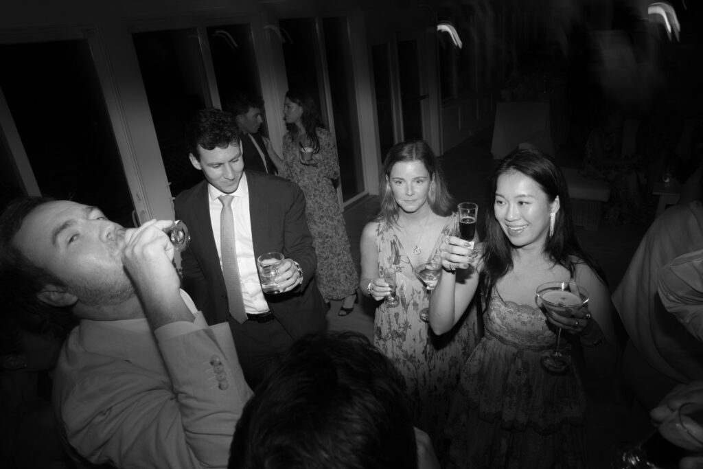 Wedding guests drinking cocktails and champagne at a Bridgehampton Tennis & Surf Club reception.