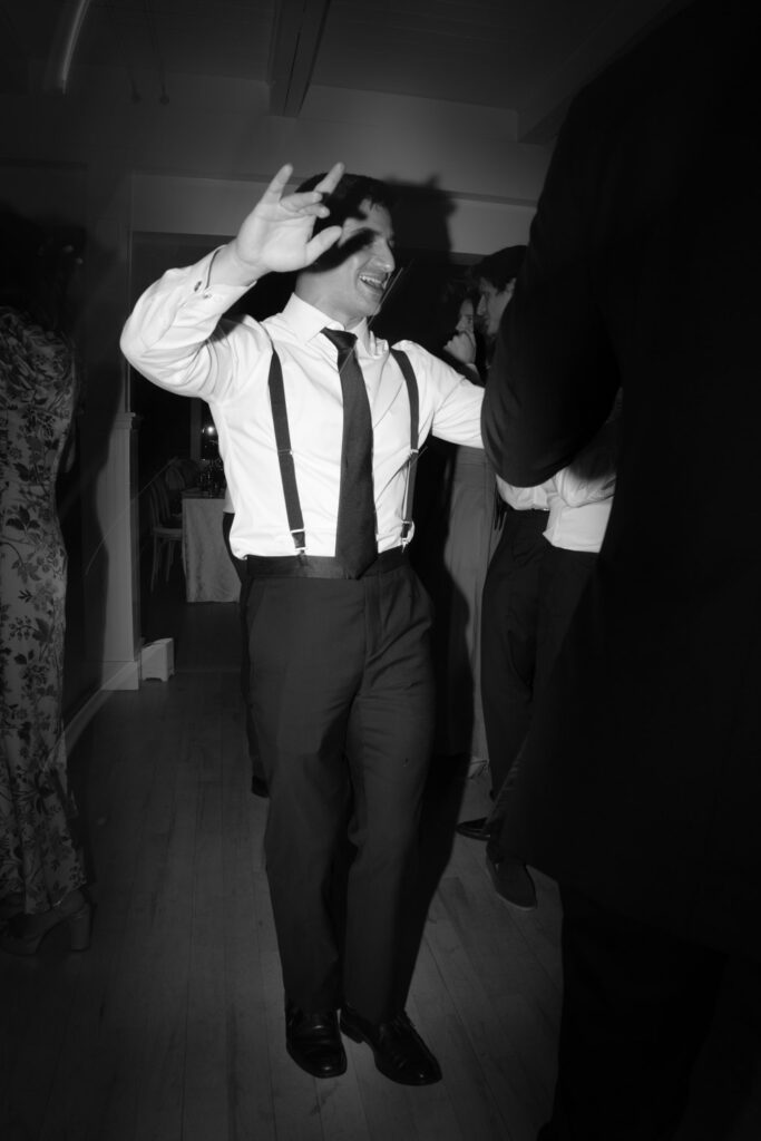A man in suspenders dances at a Bridgehampton Tennis & Surf Club wedding reception in New York.