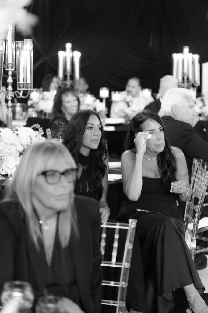 A woman wipes her eye at a formal wedding reception at Russos on the Bay.