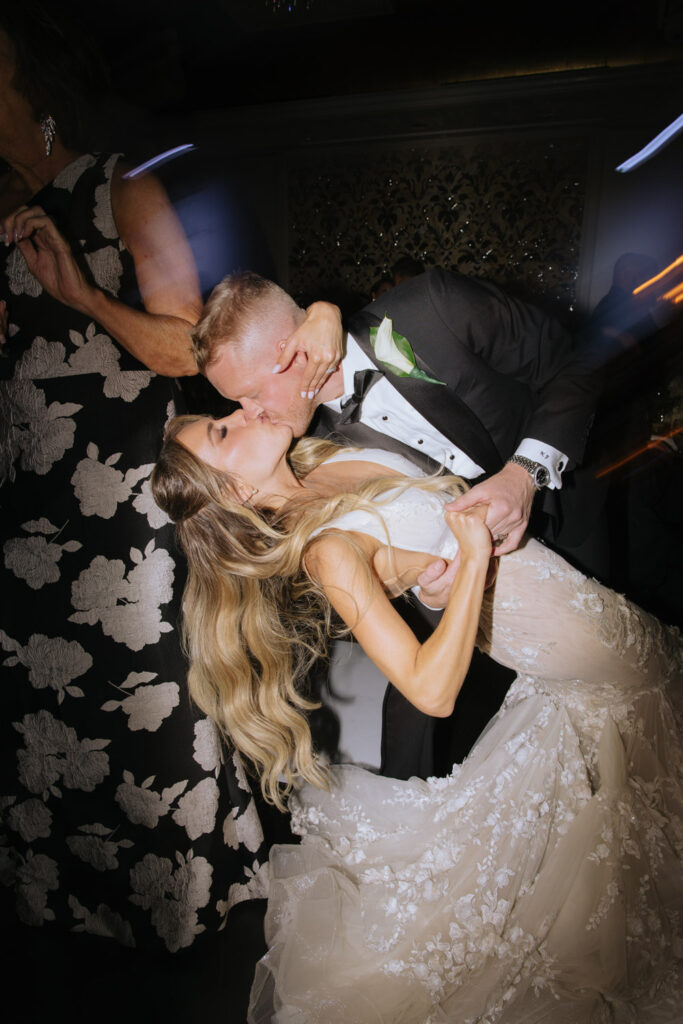 A newlywed couple kisses and dances at their Russos on the Bay wedding reception.