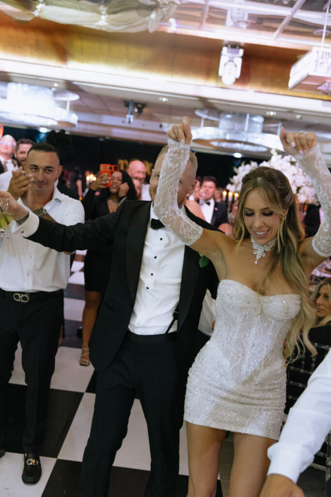A couple dancing on a checkerboard floor, celebrating at their wedding reception at Russos on the Bay.