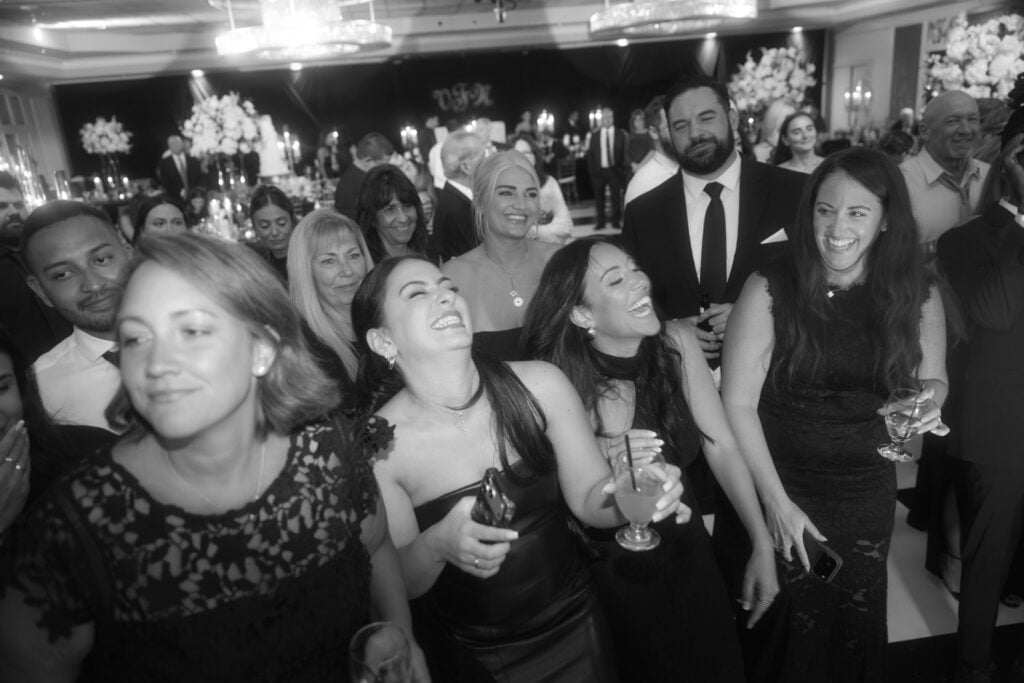 Wedding guests laughing and socializing at a reception at Russos on the Bay in New York.