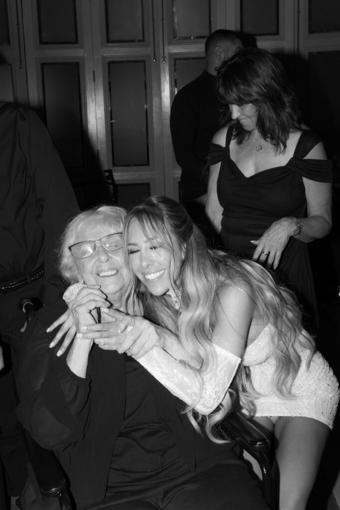 A woman embraces an older woman in a wheelchair during a wedding reception at Russos on the Bay.