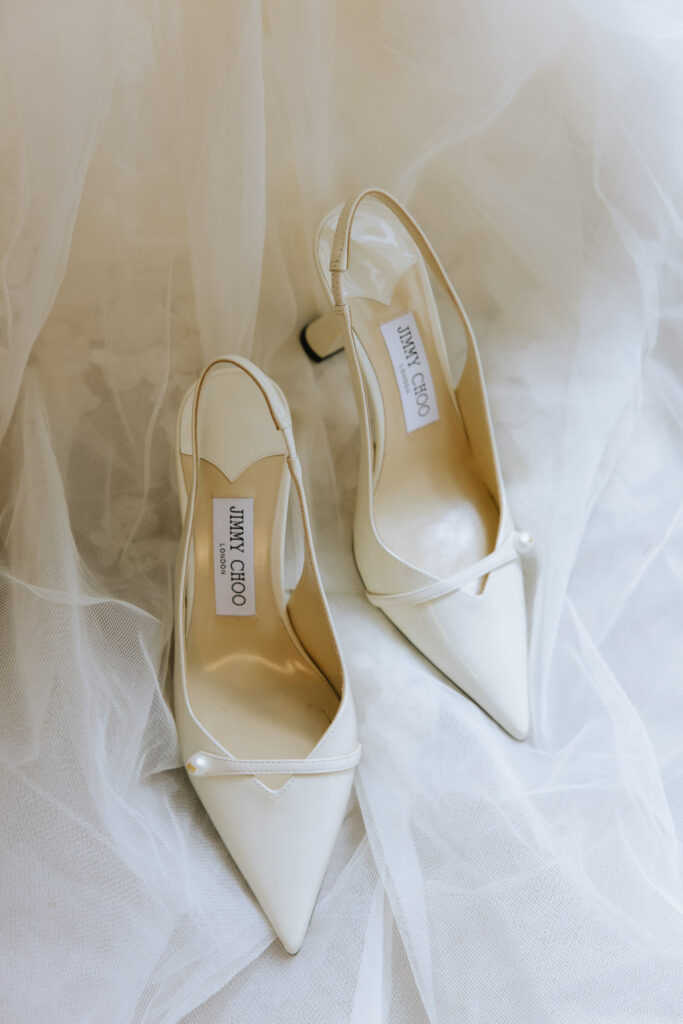White Jimmy Choo London wedding shoes with pearl accents on a white tulle dress at Russos on the Bay.