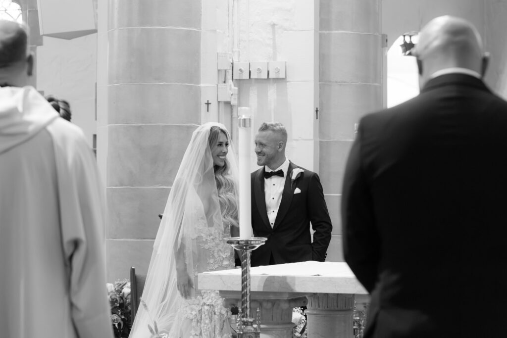 Bride and groom standing at the altar during their Catholic ceremony at Russos on the Bay.