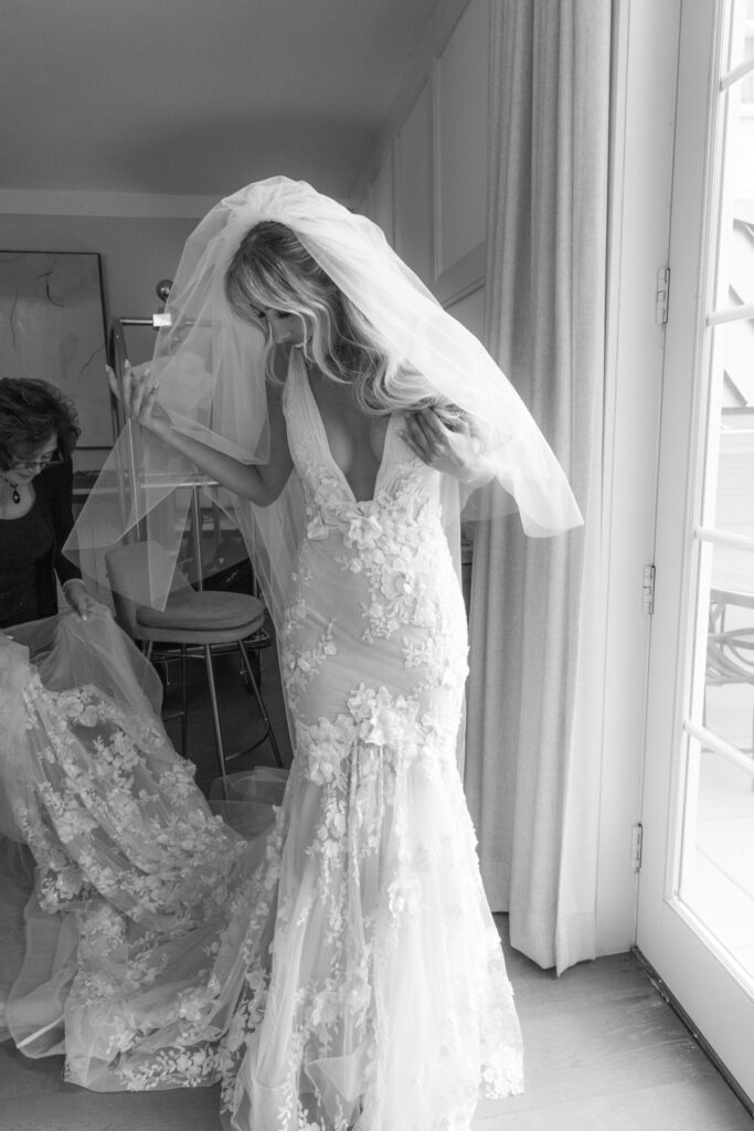 A bride adjusts her veil, a glimpse into a glamorous Russo's On The Bay wedding in Queens, New York.