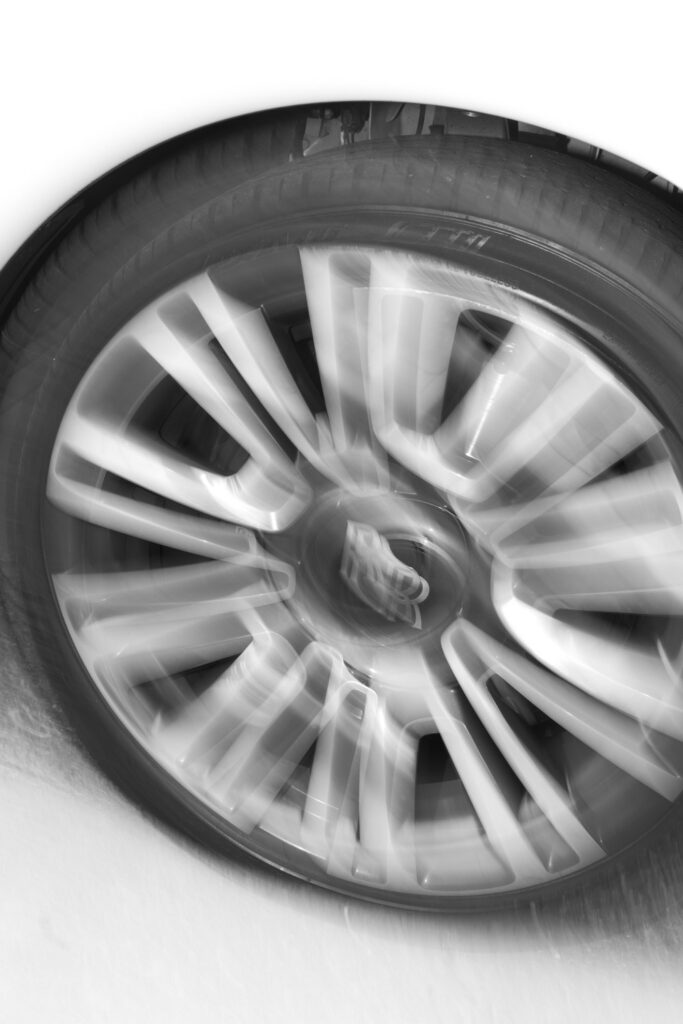 A close-up of a spinning Rolls-Royce wheel, signifying the newlyweds' exit at Russos on the Bay.