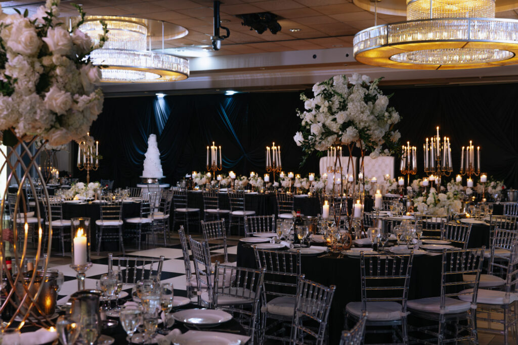 Tables set for a wedding reception at Russos on the Bay, with white floral arrangements and candles.