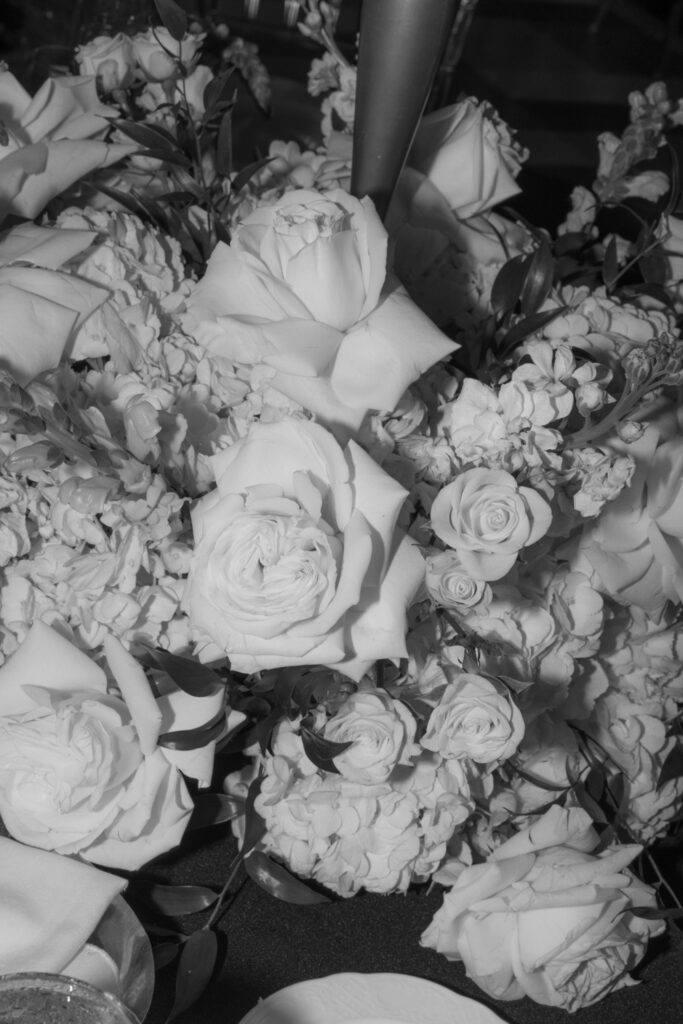 A close-up of white floral arrangements on a table during a Russos on the Bay wedding reception.