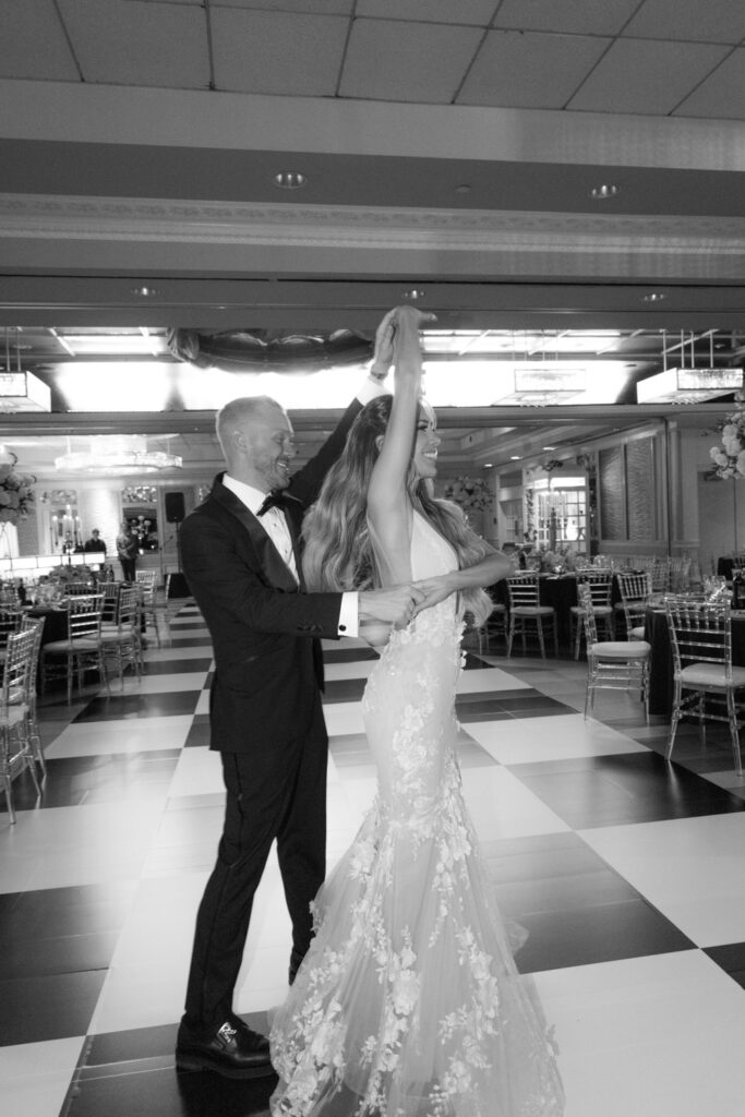 A groom and bride dance on a checkered floor during their wedding reception at Russos on the Bay.