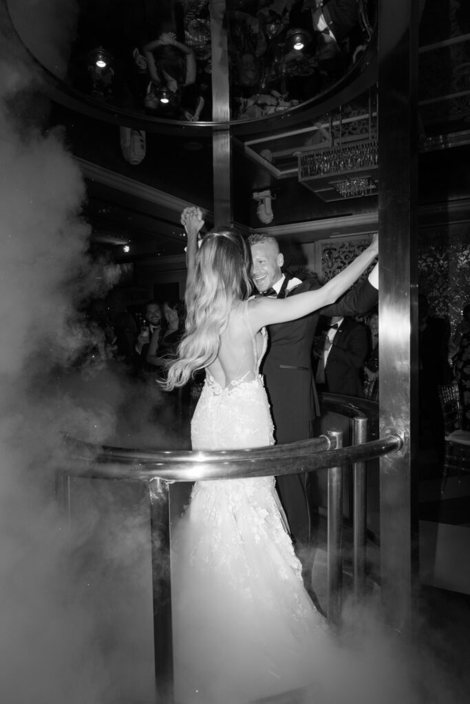 A newlywed couple performing a grand entrance in an elevator at a Russos on the Bay wedding reception.