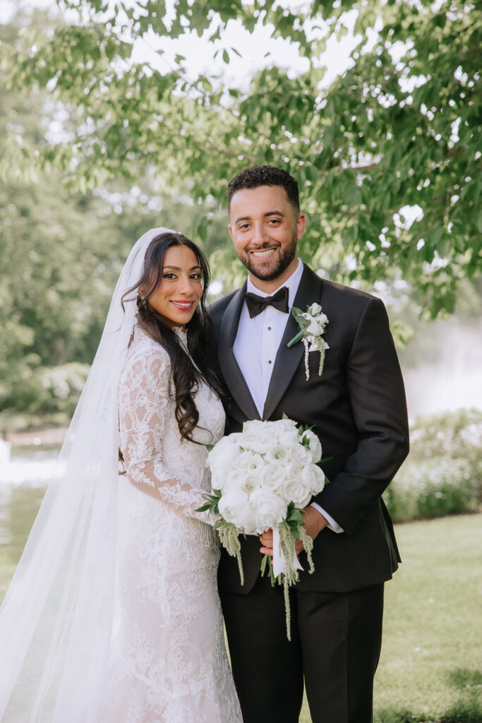Menah and Ashraf posing with a white floral bouquet at their Park Chateau Estate & Gardens wedding.