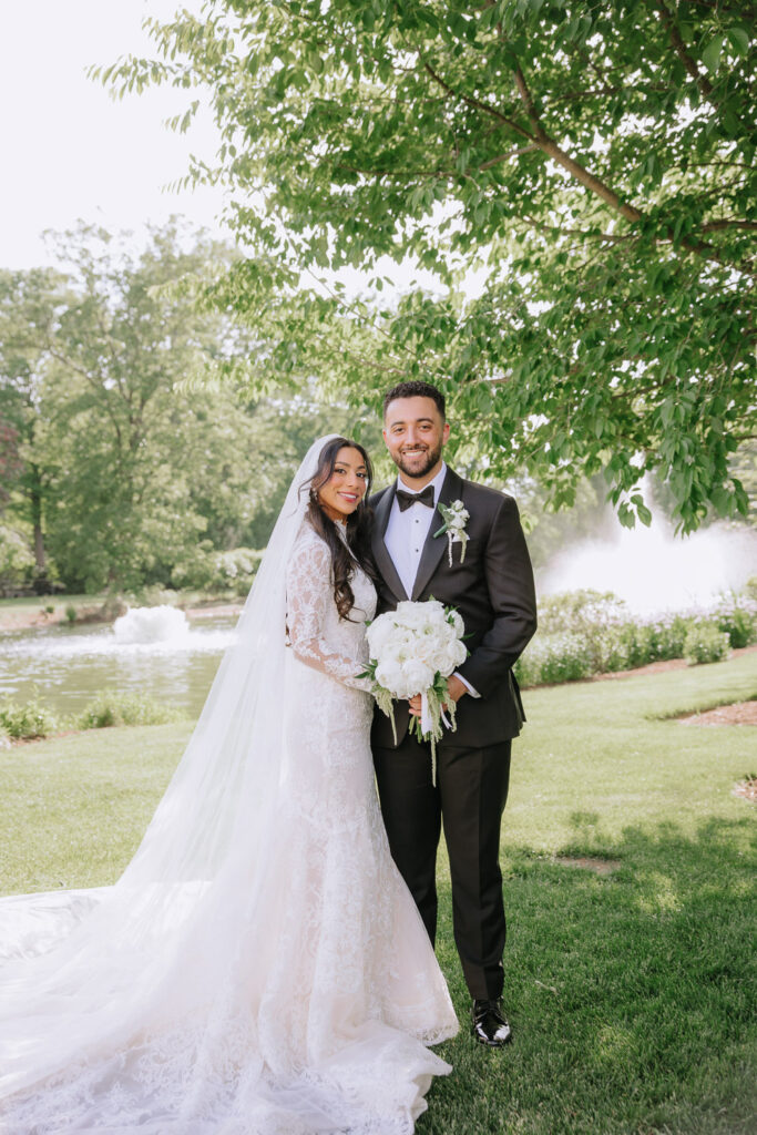A newlywed couple posing in the Park Chateau gardens during their Muslim wedding in New Jersey.