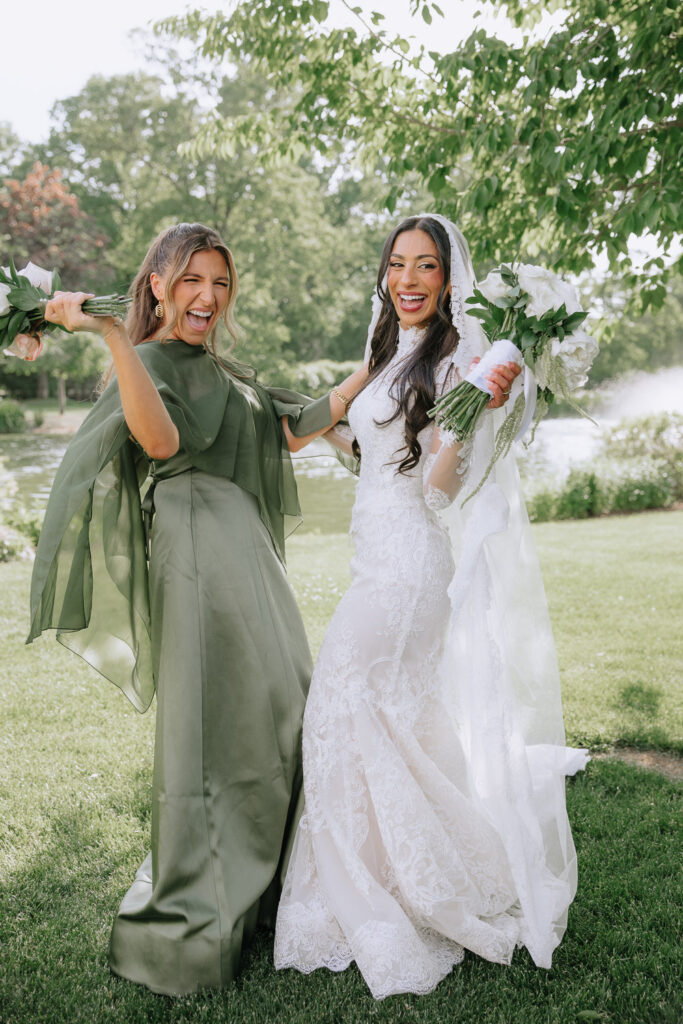 The bride and a guest laughing and holding bouquets at a Palestinian-Egyptian Muslim wedding.
