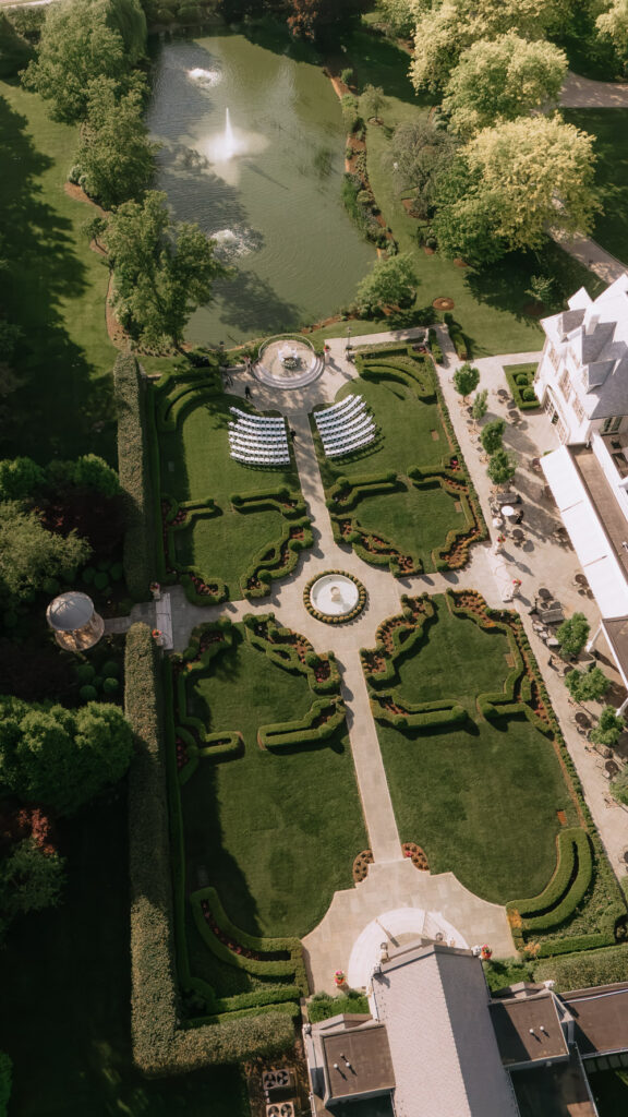 An aerial drone view shows the formal gardens and outdoor ceremony space at Park Chateau Estate & Gardens.