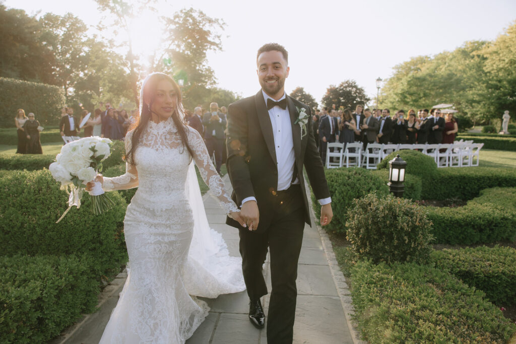 A newlywed couple walks down an aisle at Park Chateau in New Brunswick, New Jersey after their wedding.