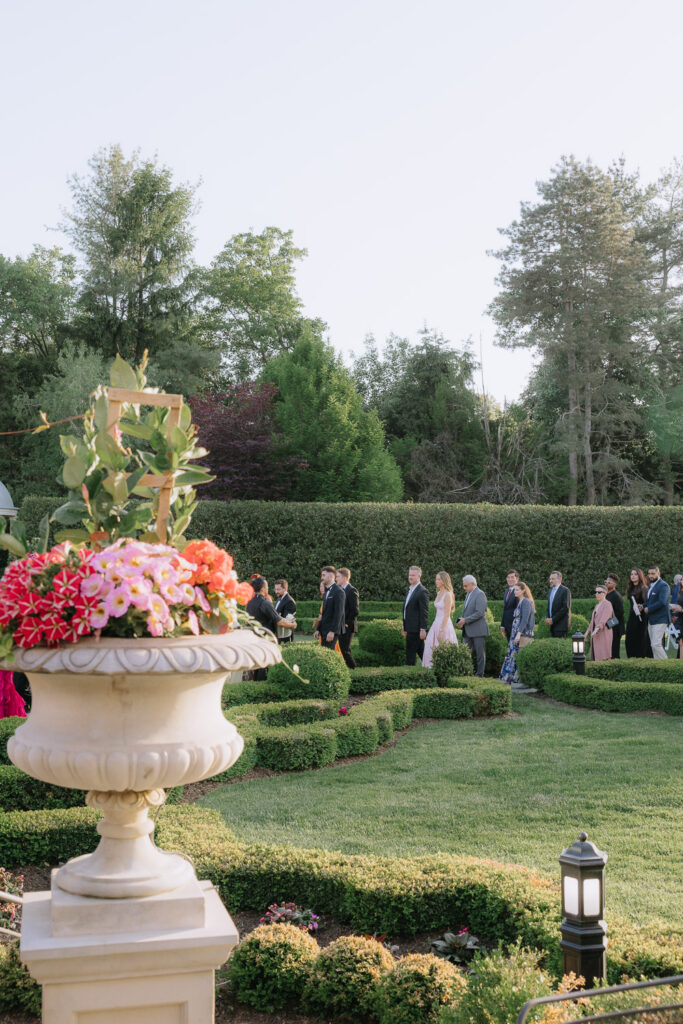 Wedding guests walk through the formal gardens at Park Chateau in New Brunswick, New Jersey.