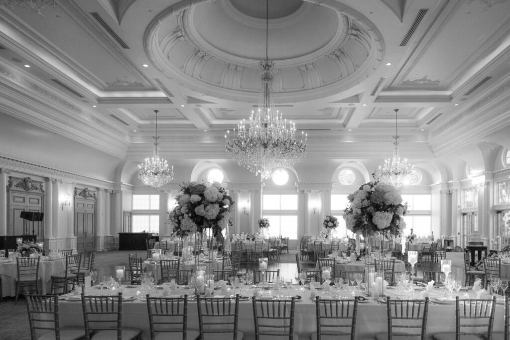 An empty ballroom with tables set for a wedding reception at Park Château Estate & Gardens.