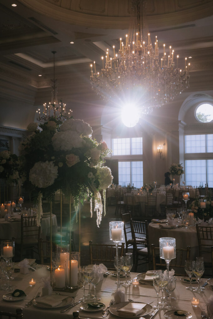 Reception hall decorated with chandeliers, grand floral centerpieces, and candlelit tables at Park Chateau.
