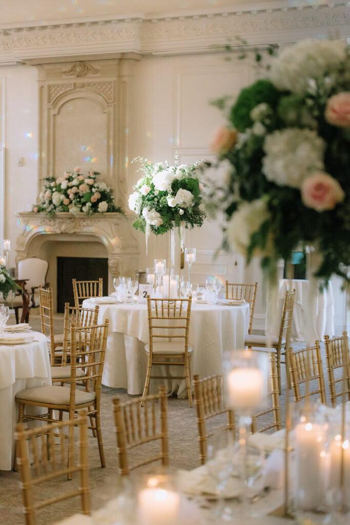 Round tables with white linens, gold chairs, and floral centerpieces at Park Chateau Estate & Gardens.