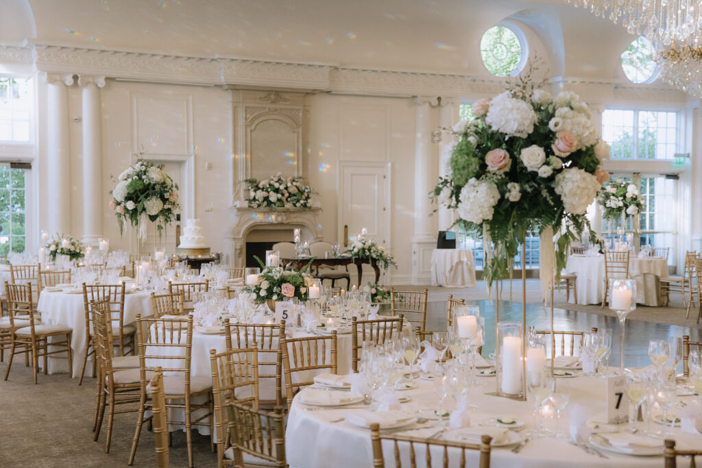 Round tables set with white linens, gold chairs, and floral centerpieces at Park Chateau New Brunswick, NJ.