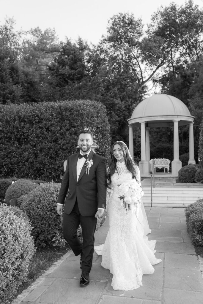 Menah and Ashraf walk hand-in-hand through the gardens at their Park Château Estate wedding.