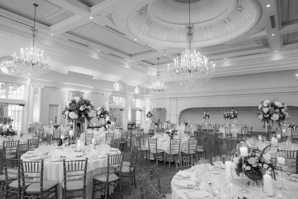 Elegant wedding reception room with chandeliers and floral centerpieces at Park Chateau in New Jersey.