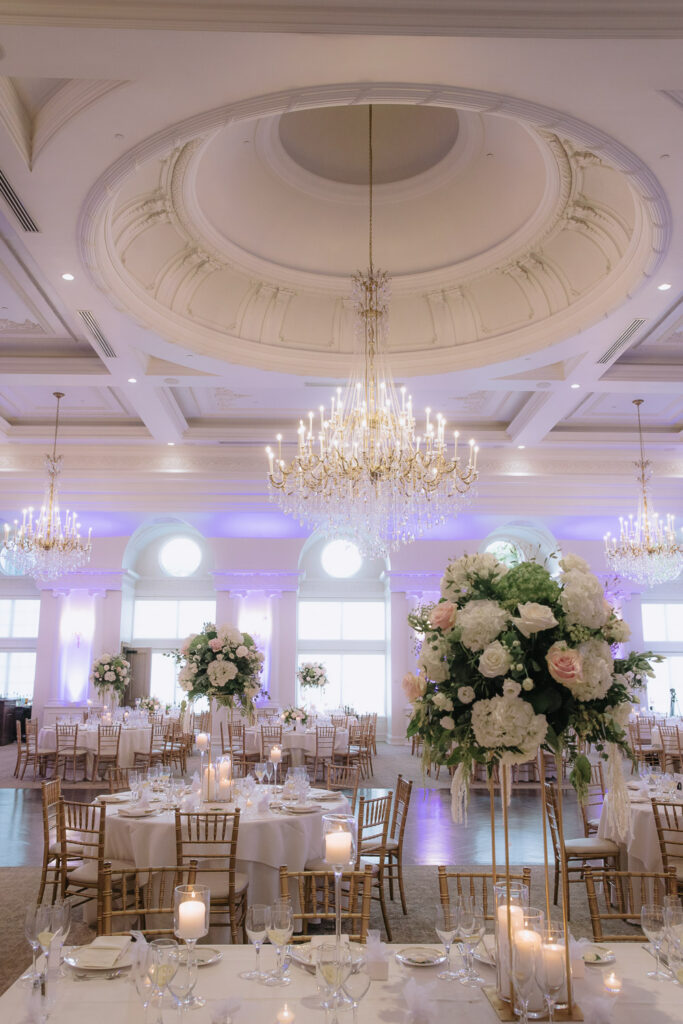 A reception hall at Park Chateau New Brunswick, New Jersey, with grand chandeliers and tables set for a wedding.