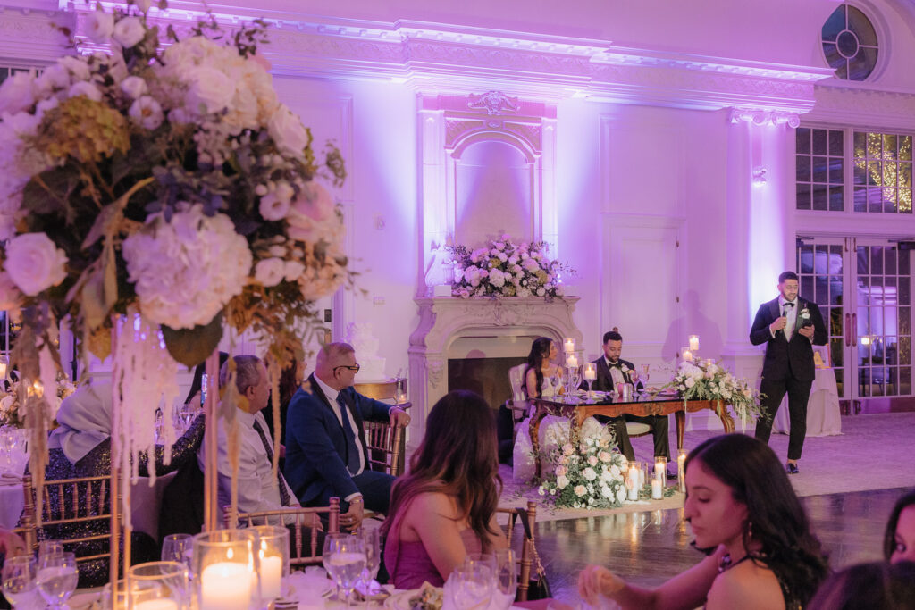 A man speaks at a wedding reception while the couple sits at the head table in Park Chateau.