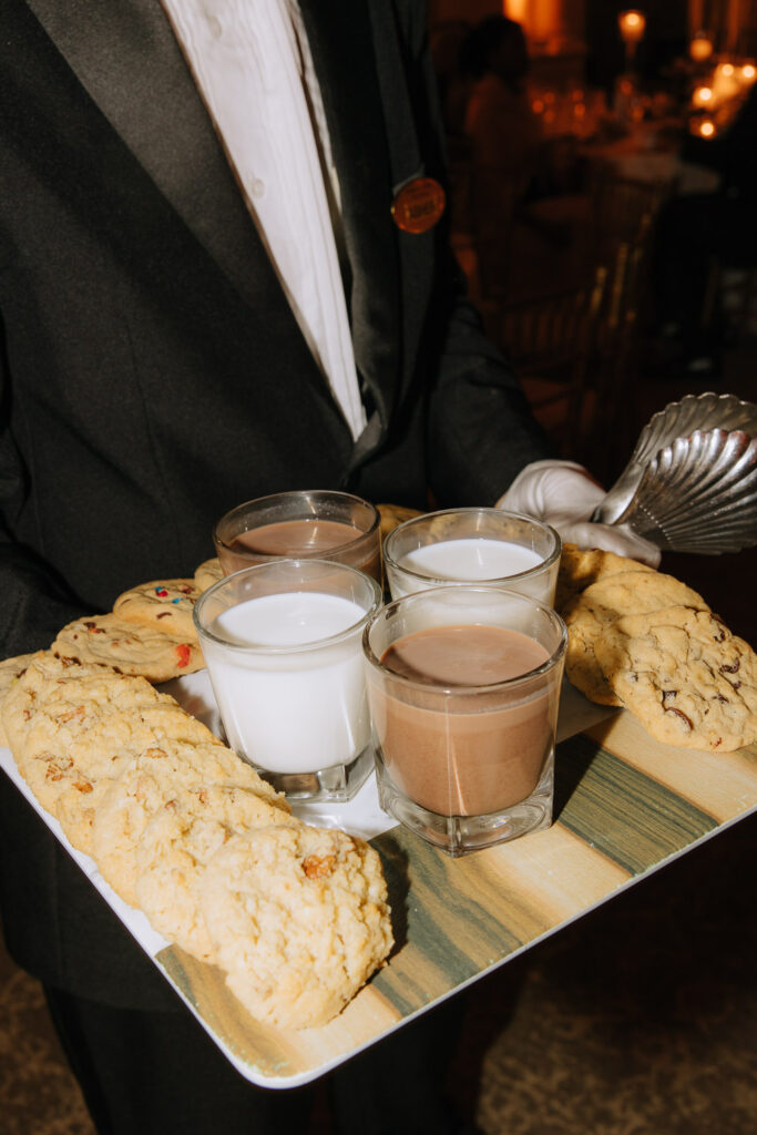 A server holds a tray of milk, chocolate milk, and cookies during a Palestinian-Egyptian Muslim wedding.