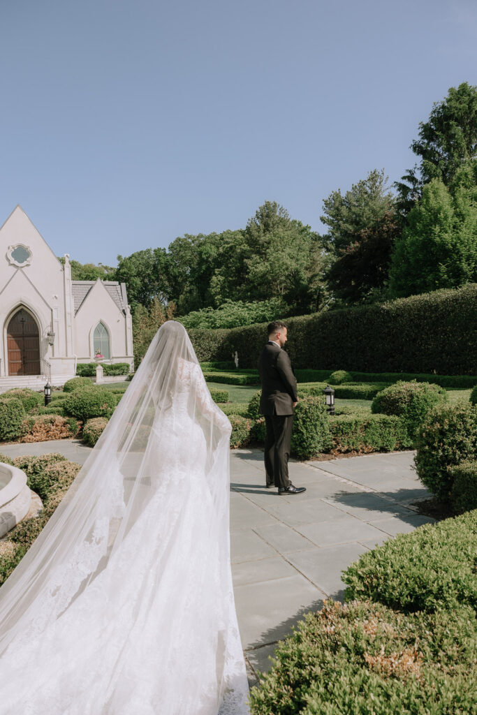 Bride approaches groom for first look at Park Chateau Estate & Gardens in East Brunswick, New Jersey.