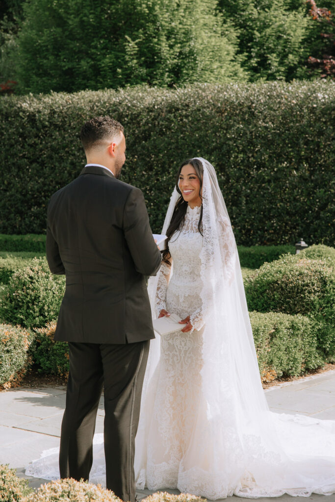 A groom looks at his bride during their wedding ceremony at Park Chateau in New Brunswick, NJ.
